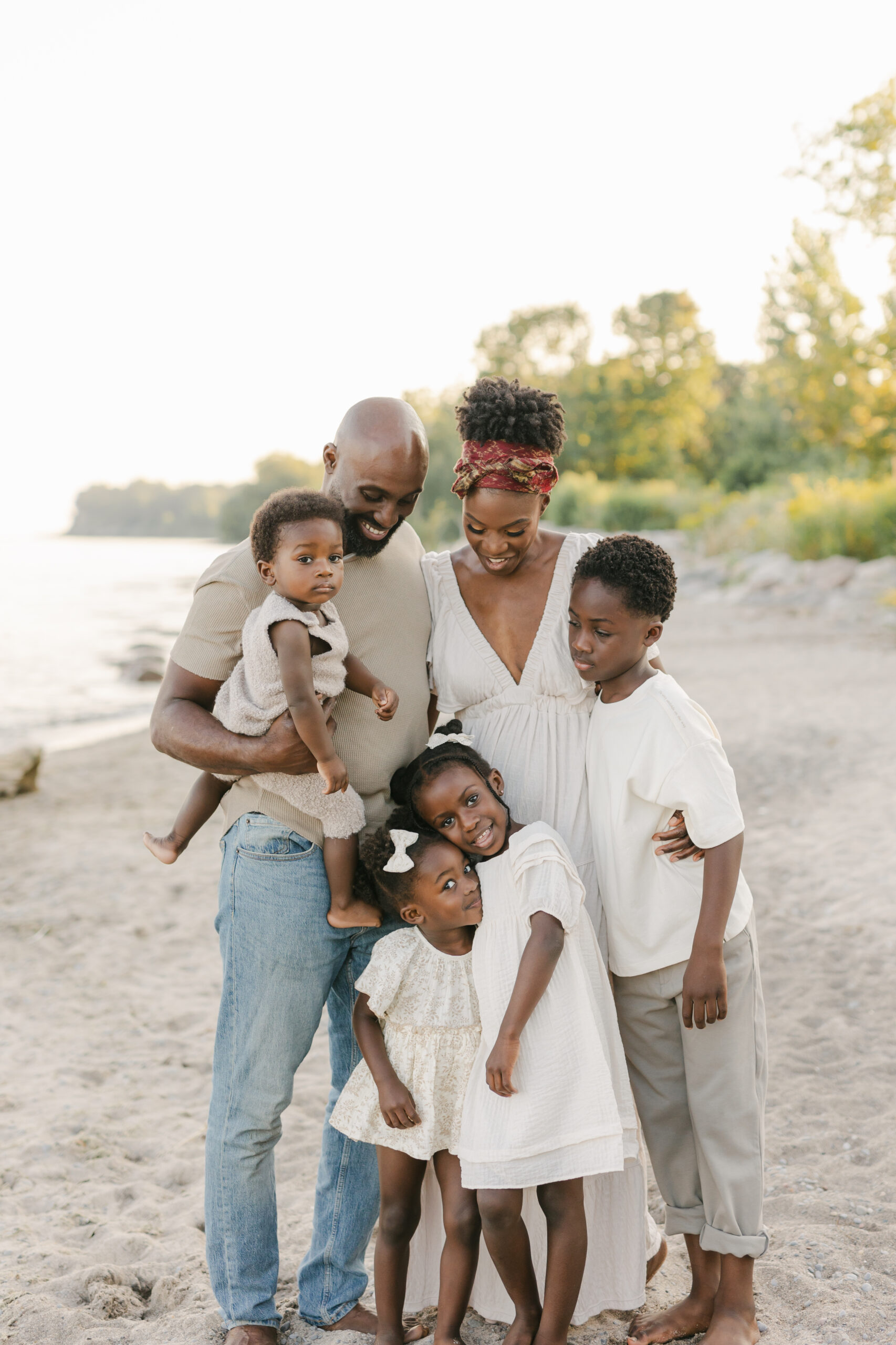 a family at a Toronto beach cuddling at sunset