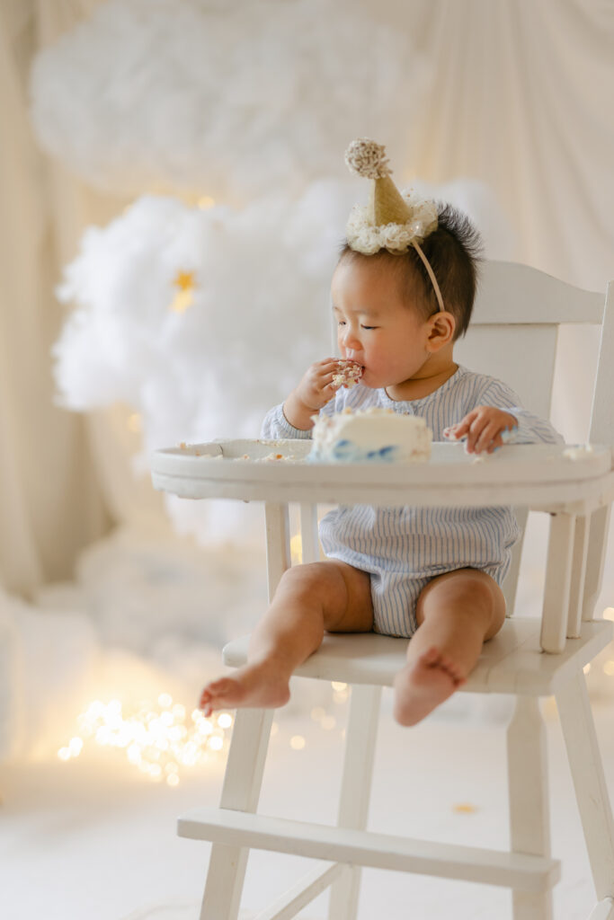 Baby is eating a cake on the highchair in Toronto